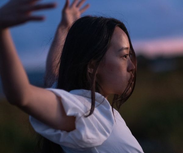 Person stretching outdoors with a serene landscape in the background.